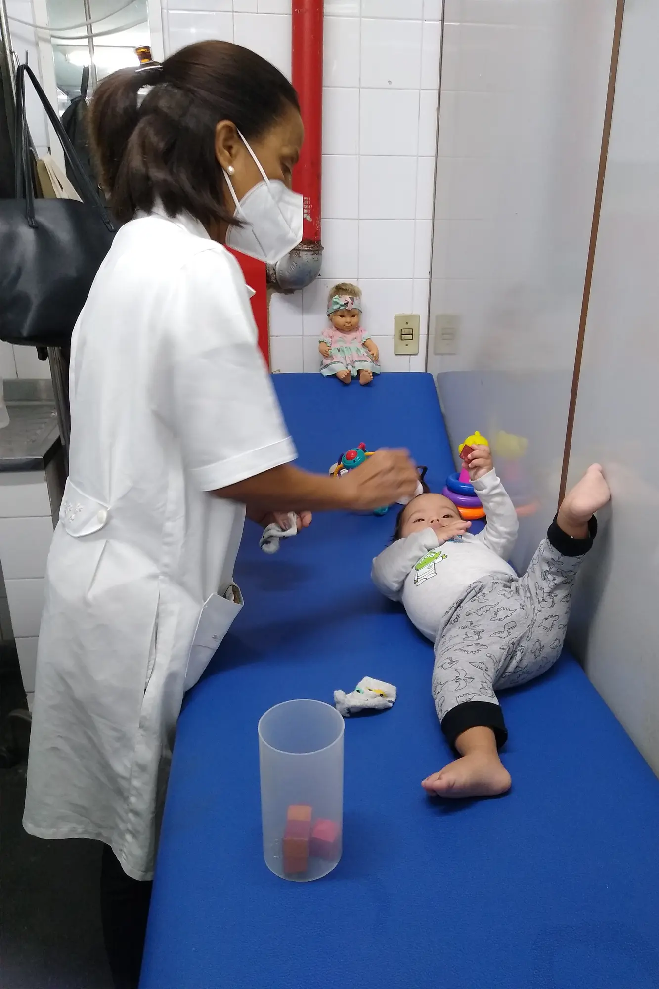 O bebê Emanuel é avaliado pela fisioterapeuta Edneusa Flor. — Foto: Licia Oliveira.