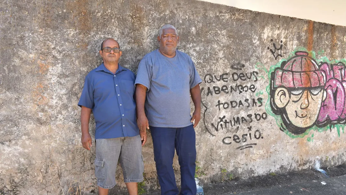 Donizeth e Marcelo em frente a muro onde era a casa de um dos catadores que desmontou a máquina de raio-x: falta um cuidado em preservar a memória. - Foto: Eduardo de Oliveira